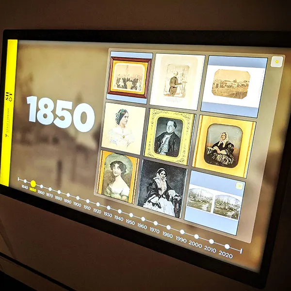 A State Library NSW touchscreen kiosk showing an 1850 photographic timeline