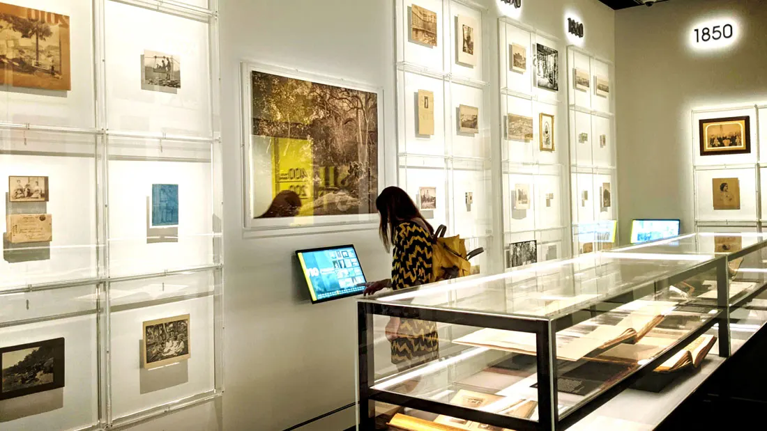 A visitor using a touchscreen kiosk in the State Library NSW Photographic Galleries